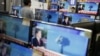 A sales assistant watches TV sets broadcasting a news report on North Korea's nuclear test, in Seoul, Jan. 6, 2016.