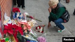 A man reacts at a makeshift memorial at the scene where two police officers were fatally shot in the Brooklyn borough of New York, Dec. 21, 2014. The two New York City police officers, Wenjian Liu and Rafael Ramos, were shot and killed as they sat in a ma