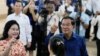 Perdana Menteri Kamboja Hun Sen (kanan) dan istrinya Bun Rany (kiri) memperlihatkan jari telunjuk yang sudah ditandai tinta usai memasukkan surat suara di sebuah TPS di Takhmua, Provinsi Kandal, Pnom Penh, Kamboja, Minggu 23 Juli 2023. (Foto: Heng Sinith/AP Photo)