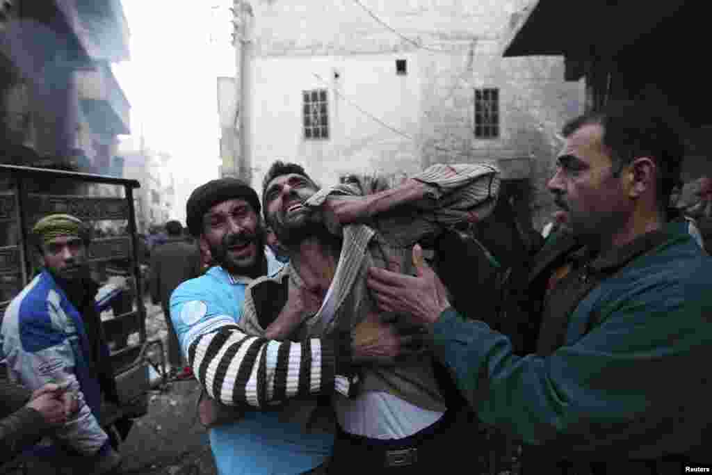 A father reacts after the death of two of his children whom activists said were killed by shelling by forces loyal to Syria's President Bashar al-Assad, in al-Ansari, Aleppo, Syria, January 3, 2013.