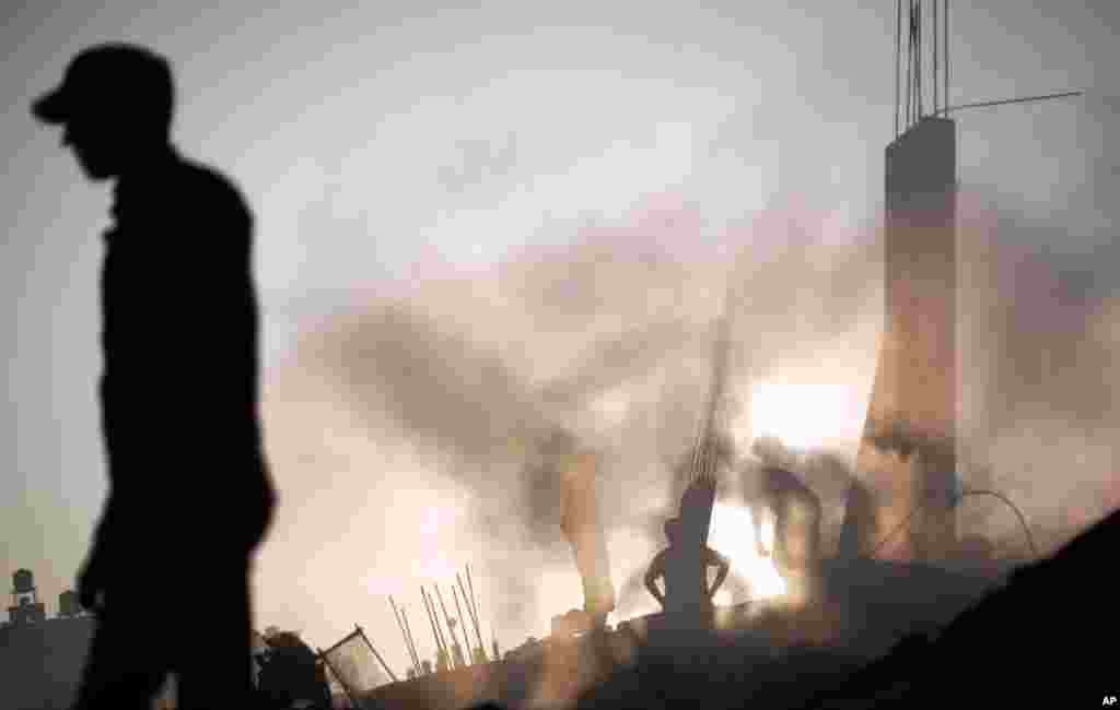 Palestinians search through the rubble of a house destroyed by an overnight Israeli airstrike in Gaza City, July 8, 2014.
