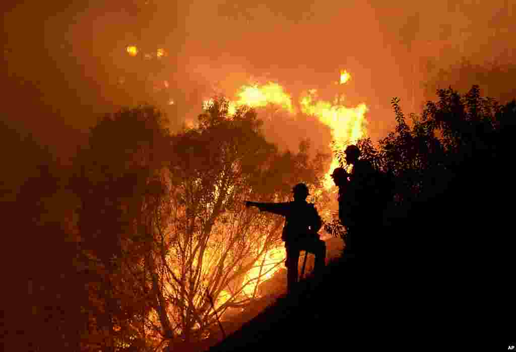 Seorang petugas pemadam kebakaran berusaha memadamkan kebakaran hutan di Lembah Simi, California, AS. 