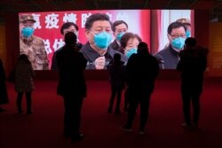 FILE - Residents attend an exhibition on the city's fight against the coronavirus in Wuhan, China, Jan. 23, 2021.