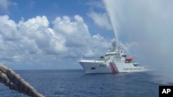 Penjaga Pantai China mendekati kapal nelayan Filipina di Scarborough Shoal, Laut China Selatan, yang juga disebut Laut Filipina Barat, 23 September 2015.