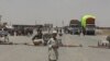FILE - A boy stands at the closed Chaman border crossing between Pakistan and Afghanistan with trucks seen stranded in the background.