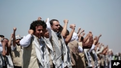 FILE - In this Oct. 16, 2020, file photo, Yemeni prisoners chant slogans during their arrival after being released by the Saudi-led coalition at the airport in Sanaa, Yemen.