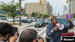 Un manifestant bloque la circulation pendant que d'autres protestaires avancent lors d'une manifestation pour Freddie Gray, jeune noir mort alors qu'il était en détention par police, à Baltimore, Maryland, 2 septembre 2015.