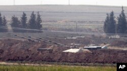 In this Oct. 6, 2019 photo, Turkish forces artillery pieces are seen on their new positions near the border with Syria in Sanliurfa province, Turkey. 