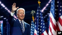 FILE - Democratic presidential candidate Joe Biden waves as he stands on stage on the third day of the Democratic National Convention, at the Chase Center in Wilmington, Del., Aug. 19, 2020.