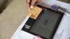 Vérification de l'identité d'un électeur grâce à une tablette dans un bureau de vote, à Port Bouet, lors des élections locales à Abidjan en Côte d'Ivoire le 16 décembre 2018.