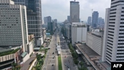 Jalan Thamrin menuju bundaran Hotel Indonesia (HI) yang biasanya padat tampak sepi pada hari kelima pembatasan sosial besar-besaran, Jakarta,14 April 2020. (Foto: AFP)