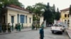 FILE - Policemen and security staff stand outside the main entrance gate of Ho Chi Minh City's People's Court where three bloggers stand trial for 'anti-state propaganda,' September 2012.