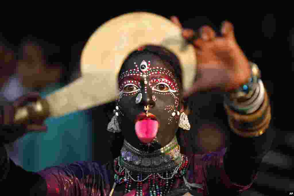 A folk artist from India’s northern Uttar Pradesh state performs during a procession held as part of the ongoing all India multilingual short play, folk dance competition and theater seminar in Allahabad.