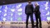 Two men stand in front of an information board at the Russia's Central Election Commission office in Moscow on September 8, 2023. (Photo by AFP)