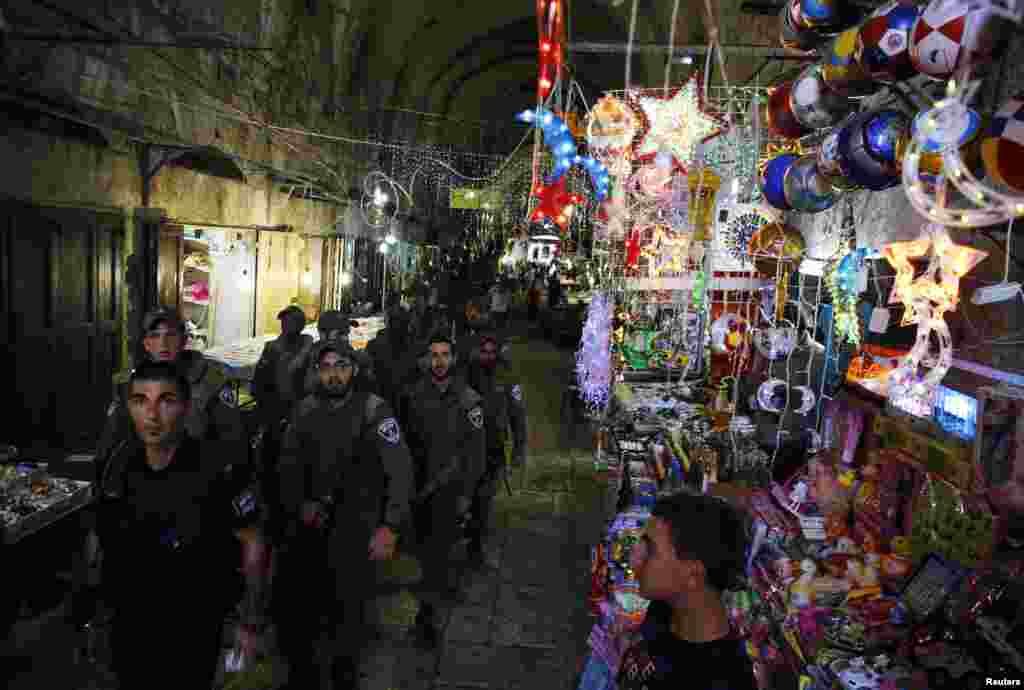 Tentara keamanan Israel melewati toko yang menjual dekorasi Ramadan saat mereka berjaga di kota tua Yerusalem (8/7).