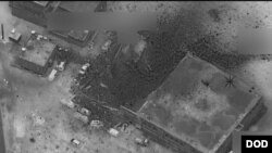 The site of an al-Qaida senior leader meeting in al-Jinah, Syria, is shown after being hit by an airstrike March 16. The photo shows what appears to be an intact, undamaged mosque next to a larger building that apparently suffered multiple weapons strikes.