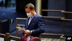 Luxembourg's Prime Minister Xavier Bettel waits for his car as he leaves the European Council building in the early morning during an EU summit in Brussels, Monday, July 20, 2020. Leaders from 27 European Union nations met throughout the night…