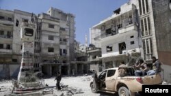 Pemberontak memeriksa lokasi yang hancur akibat serangan udara yang dilakukan oleh pasukan yang setia kepada Presiden Suriah Bashar al-Assad di kota Jisr al-Shughour, setelah para pemberontak menguasai wilayah tersebut, 26 April 2015.