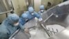 FILE - Employees work on the production line of an anti-malarial drug at a pharmaceutical company in Nantong, Jiangsu province, China, Feb. 27, 2020.