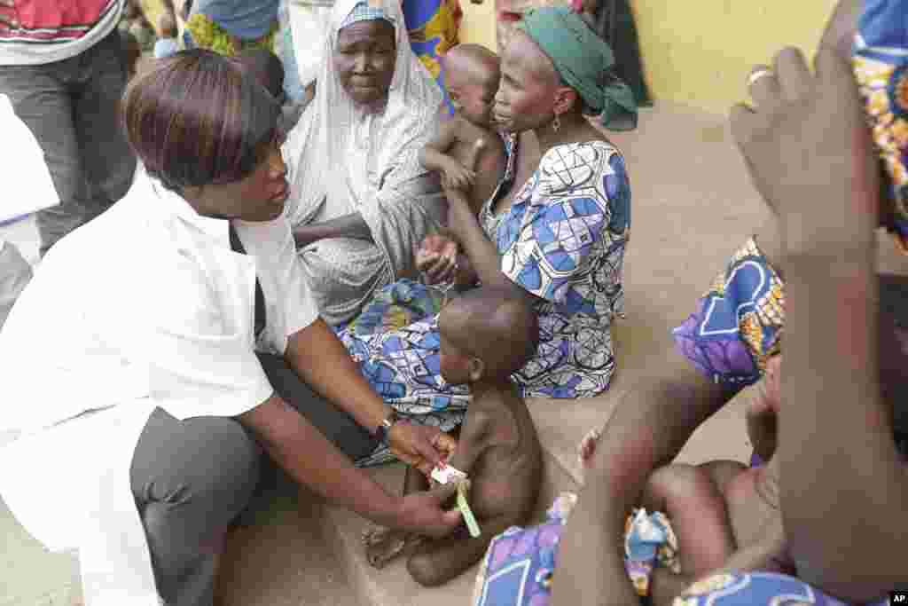 A doctor attends to a Malnourished child as women and children rescued by Nigerian soldiers wait to receive treatment at a refugee camp in Yola, Nigeria, after being rescued from captivity by Boko Haram fighters, May 3, 2015.