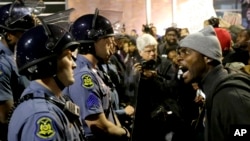 Seorang demonstran membentak seorang polisi di markas besar kepolisian di Ferguson, Missouri (10/10).