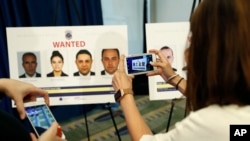 Wartawan memfoto poster orang-orang yang menghadapi tuntutan pidana akibat perkelahian diluar kedutaan Besar Turki di Washington bulan lalu.