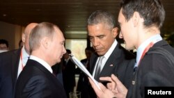 FILE - U.S. President Barack Obama (2nd R) talks to his Russian counterpart Vladimir Putin (L, front) during the Asia Pacific Economic Cooperation (APEC) Summit in Beijing, Nov. 11, 2014. 
