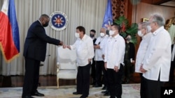 Menteri Pertahanan AS Lloyd Austin (kiri) bersalaman degan Presiden Filipina Rodrigo Duterte dalam pertemuan di Istana Malacanang, 29 Juli 2021.