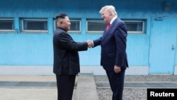 FILE - U.S. President Donald Trump shakes hands with North Korean leader Kim Jong Un as they meet at the demilitarized zone separating the two Koreas, in Panmunjom, South Korea, June 30, 2019. 