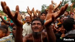Pengungsi Rohingya mengulurkan tangan mereka menerima bantuan makanan yang diberikan oleh organisasi lokal di Kutupalong, Bangladesh, 9 September 2017.