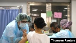 A nurse administers a dose of the AstraZeneca vaccine against the coronavirus disease