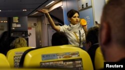FILE - A Ryanair air steward demonstrates safety procedures before take-off at Dublin airport in Dublin, Ireland, Sept. 27, 2017. 