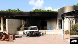 This file photo taken on September 12, 2012 shows a burnt house and a car inside the US embassy compound in Benghazi following an overnight attack on the building.