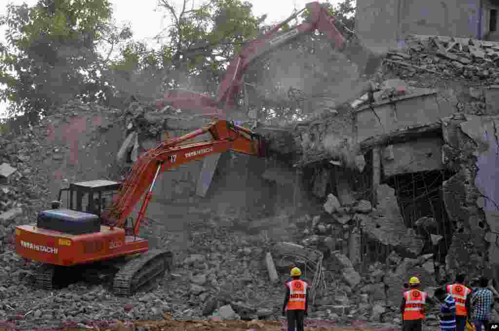 Para anggota Pasukan Penanggulangan Bencana Nasional India (NDRF) India&#39;s National Disaster Response Force (NDRF) mengawasi pembersihan puing-puing dari reruntuhan gedung yang ambruk di Canacona, India (5/1). (AP/Rafiq Maqbool)