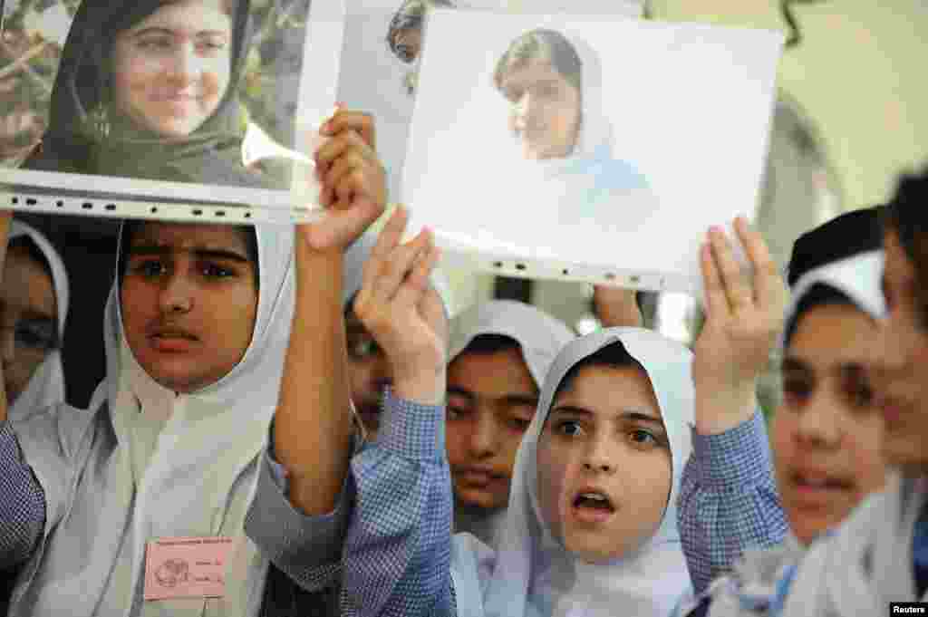 Students hold pictures of schoolgirl Malala Yousafzai, who was shot by the Taliban, during a tribute at the Pakistani Embassy in Abu Dhabi, October 15, 2012.