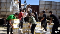 Warga Suriah membawa bantuan kemanusiaan yang disediakan oleh PBB, World Food Program (WFP) dan Bulan Sabit Merah Arab Suriah di kota yang dikuasai pemberontak di pinggiran Homs di Suriah pusat, 25 Mei 2016. (Foto: dok.)