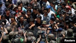 Protesters against military rule and soldiers deployed to control them confront each other at Bangkok's shopping district, May 25, 2014. 