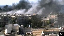 This video image taken from amateur video and broadcast by Bambuser/Homslive shows a series of devastating explosions rocking the central Syrian city of Homs, Syria, Monday, June 11, 2012. 