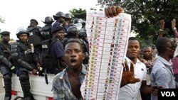 Para pendukung tokoh oposisi Etienne Tshisekedi menunjukkan kartu suara 'bermasalah' yang mereka temukan di salah satu TPS Kinshasa (28/11).