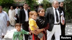 Khalida Bibi (tengah), saudara perempuan Farzana Iqbal, didampingi pengacara saat tiba di pengadilan Lahore untuk sidang para tersangka pembunuhan adiknya, Juni 2014.