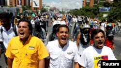 FILE - Deputies of the opposition parties Carlos Paparoni, left, Jose Manuel Olivares, center, and Juan Mejia shout slogans during a march to state ombudsman's office in Caracas, Venezuela, May 29, 2017.