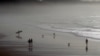 FILE - People walk on the beach of Biarritz, southwestern France, along the Atlantic Ocean, Dec. 18, 2015. New research shows the oceans are storing much more heat than previously thought.