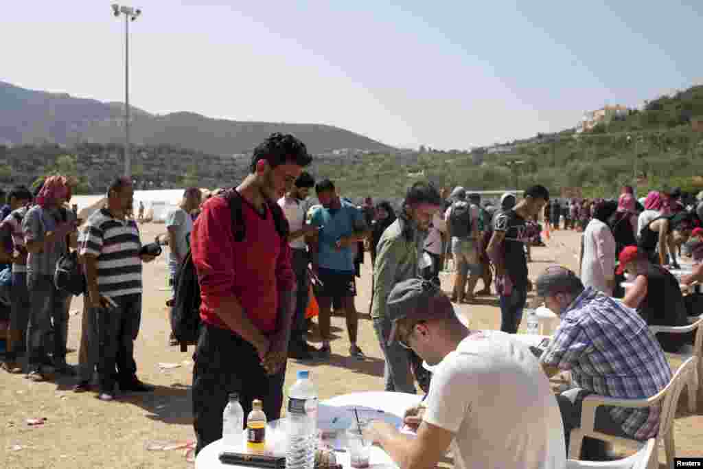 Refugees and migrants register at a registration center at the city of Mytilene, on the Greek island of Lesbos. Greece asked the European Union for aid to prevent it being overwhelmed by refugees, as a minister said arrivals on Lesbos had swollen to three times as many as the island could handle.