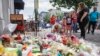 Mourners bring flowers to a makeshift memorial, Aug. 6, 2019, for the slain and injured in the Oregon District after a mass shooting early Sunday in Dayton, Ohio.