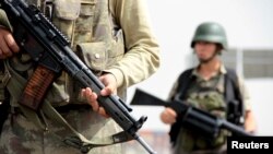 FILE - Turkish soldiers stand guard at a check point on the main road between Mardin and Cizre in southeastern Turkey. 