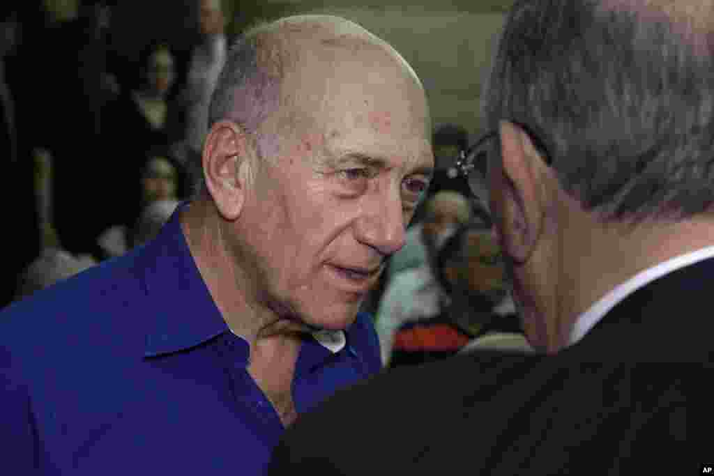 Former Israeli prime minister Ehud Olmert speaks to a lawyer upon his arrival at the Tel Aviv District Court in Israel, May 13, 2014. 