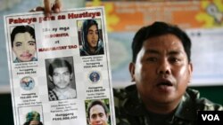 Dalam foto dari tahun 2006 ini, Pejabat militer Filipina Mayor Mabini Abduhadi menunjukkan poster bergambar tokoh Al-Qaida yang diduga terkait dengan gerakan MILF, termasuk Umar Patek (kiri bawah).