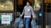 FILE - A man carries bags out of a department store, in Alameda, California, Dec. 17, 2015. Stronger-than-expected consumer spending helps ease fears of a U.S. recession.