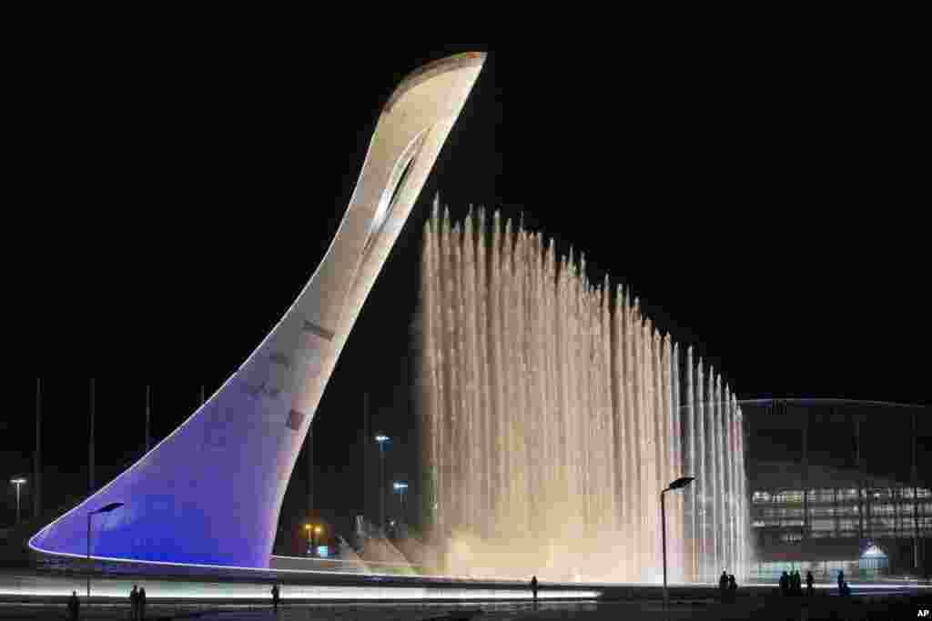 The main fountain gushes out during a test next to the Olympic flame before the start of the 2014 Winter Olympics in Sochi, Russia.