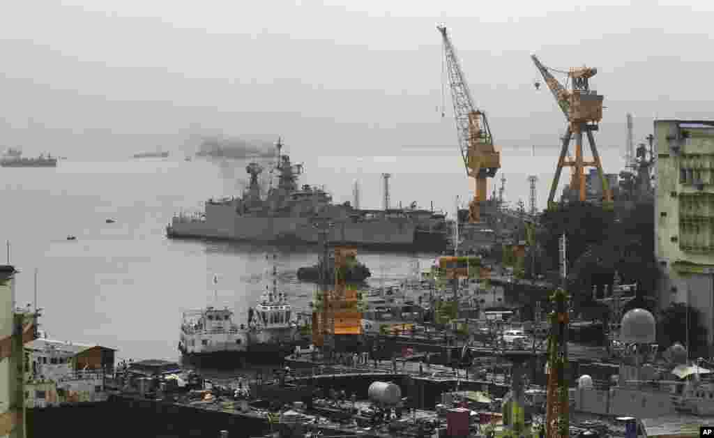 Ships ride at anchors at a naval dockyard where a submarine caught fire and sank after an explosion early Wednesday in Mumbai, August 14, 2013.